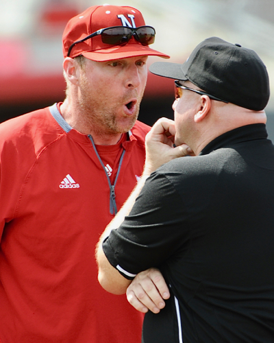 Troy's Deron Brown, who's umpiring this weekend series, gets an earful from Nebraska head coach Darin Erstad.