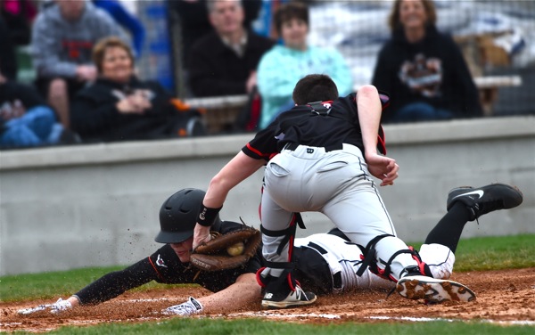 Pitcher Noah Richard slides head first past the tag attempt of Covington's Mason Dilley for the game's first run.