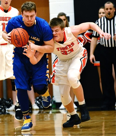Versailles' A.J. Ahrens challenges Tyler Mescher for a loose ball in first half action.