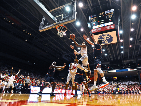 Scoochie Smith signals "field goal" (background) as Charles Cooke beats the Richmond defense to the rim.
