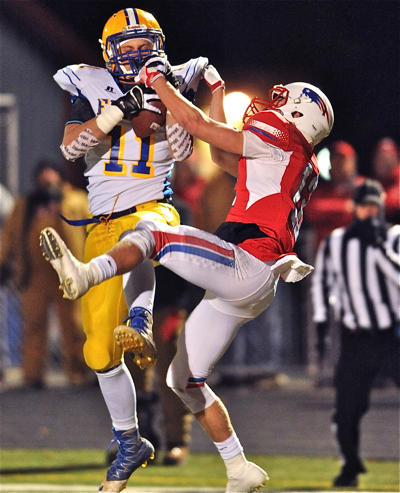 Marion's Sam Huelsman fights a Patriot defender for a two-point conversion following the Flyers' first touchdown.