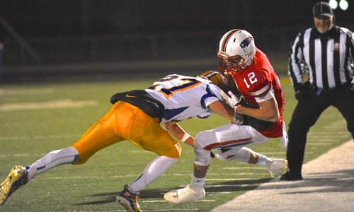 Marion's Ryan Thobe drives Patrick Henry's Alex VandeBussche out of bounds with a big hit.