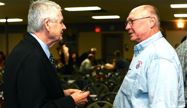 Hall of fame baseball writer Hal McCoy swaps shop with a patron of Saturday's fund-raiser in Versailles.
