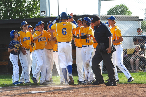 Russia's Hunter Lohee is mobbed by teammates after his solo home run in the sixth inning.