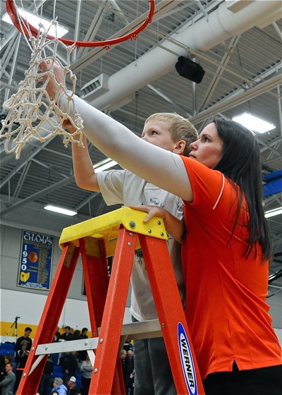 Versailles coach Jacki Stonebraker assists her son Maddox in cutting down the net.