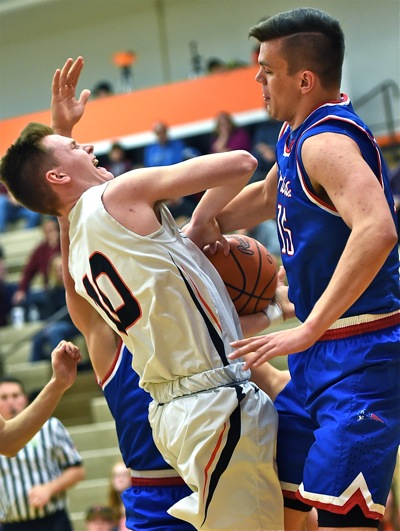 Coldwater's Marcus Bruns (in white) found it tough to score at the rim against the Patriots' 6'6" Trace Couch.