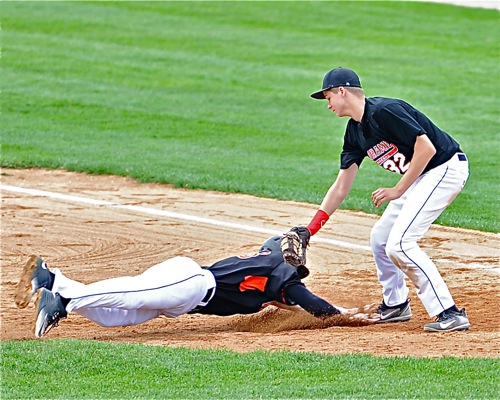 Fort Loramie first baseman Jerrod Middendorf tags out Versailles' Noah Richard attempting to get back to first base.