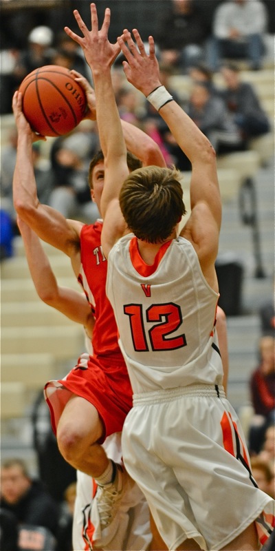 Tippecanoe's Red Devil gets sandwiched in by two Versailles Tigers while trying to make a play for the basket.